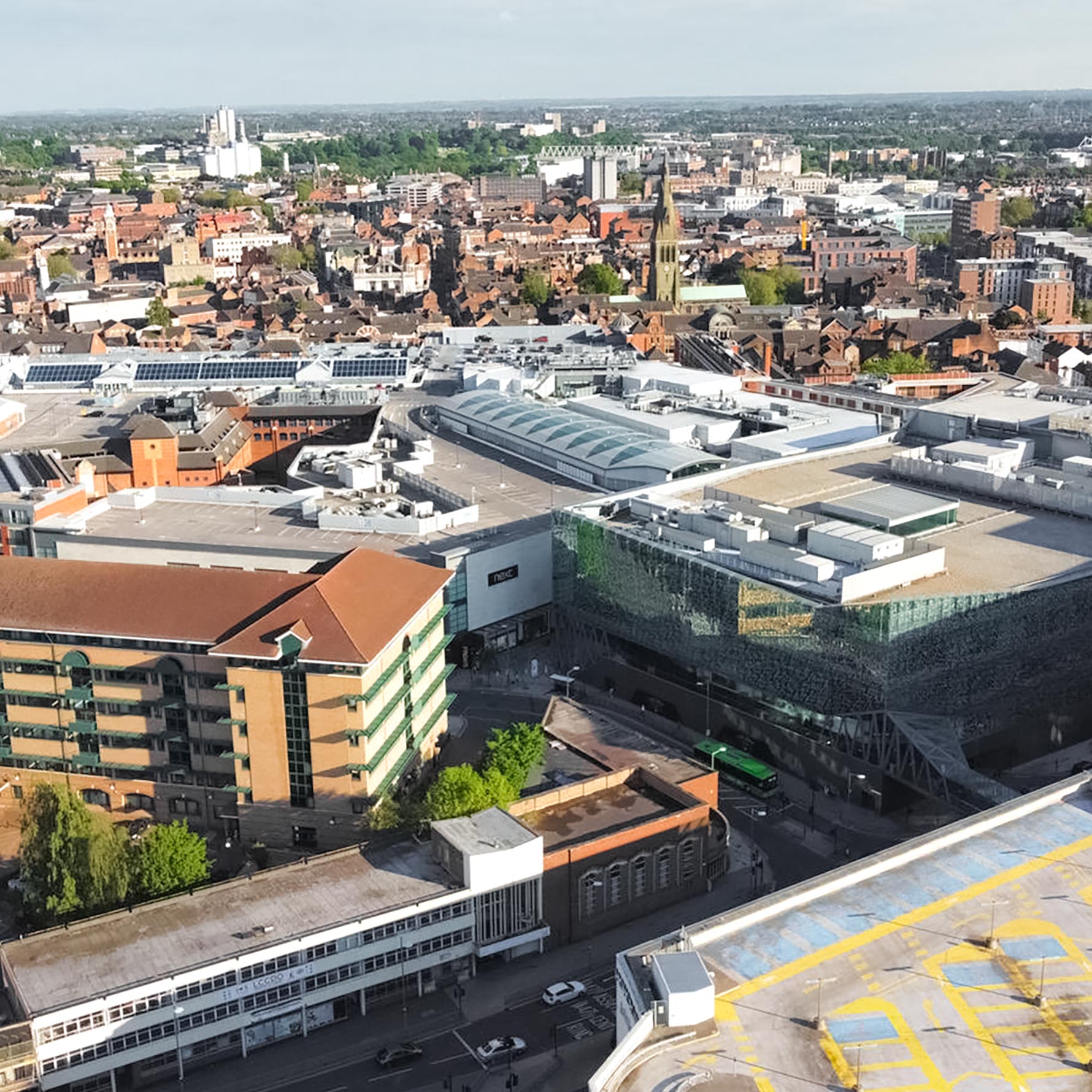 Large full width photo of Leicester City from a bird's-eye panormaic view, shows buildings in the city from a top perspective