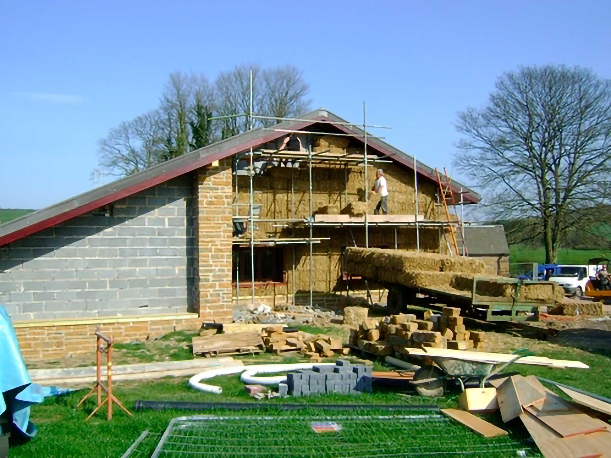 Photo of the centre showing breeze blocks and a constructor fitting in hay on scaffolding