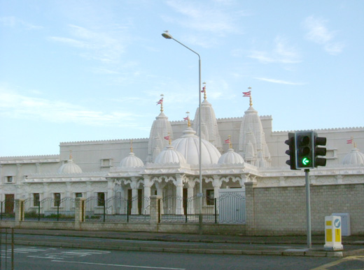 Photo of the front of the site after remodeling. Shows the new Hindu Centre with various spires